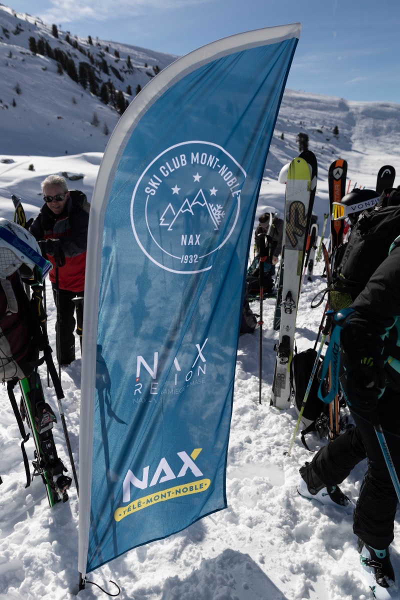 Drapeau du Ski-Club Mont-Noble planté dans la neige lors d’une sortie du 90ᵉ anniversaire